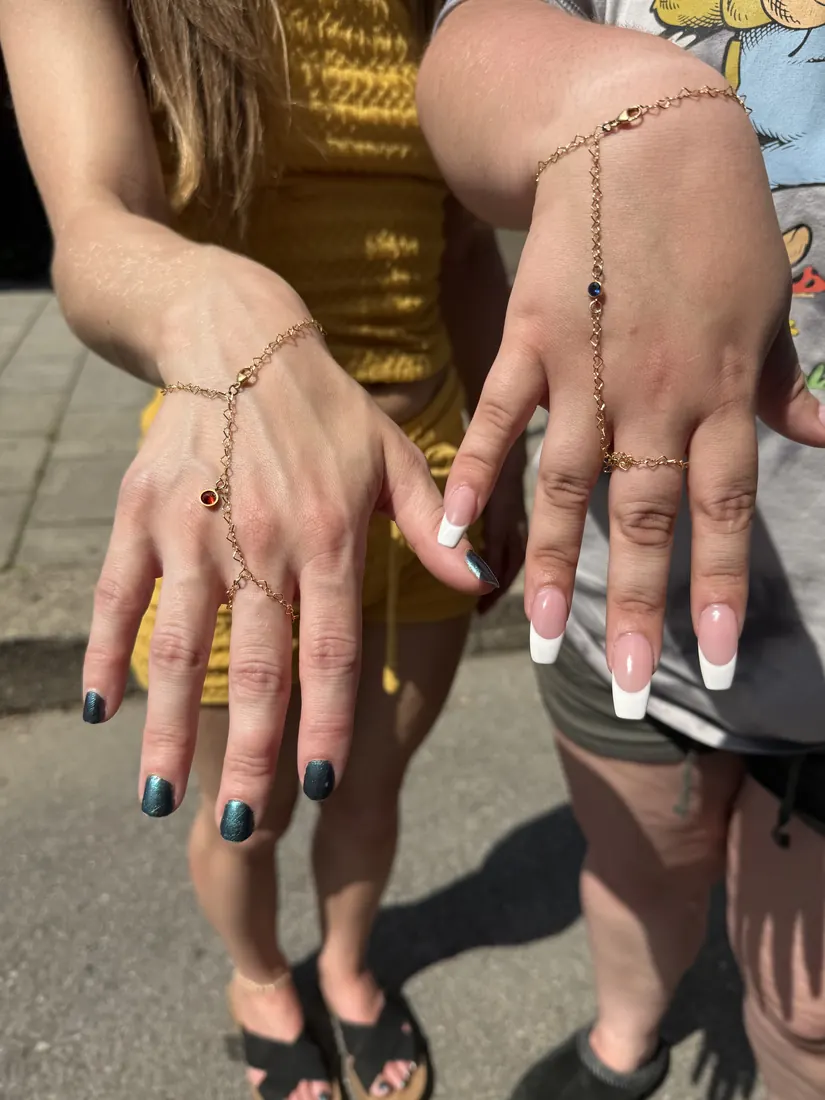 two ladies with hand chains and multiple charms